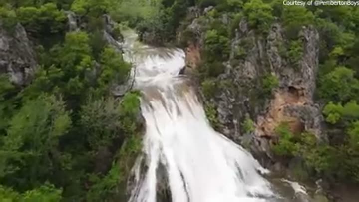 A beautiful natural waterfall cascading over rocks, showcasing Oklahoma's wild waters.