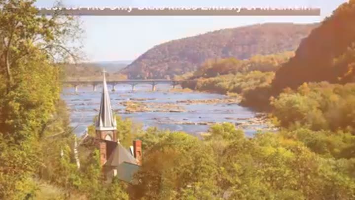 Harpers Ferry's confluence of rivers and historic bridge amidst stunning autumn mountains.