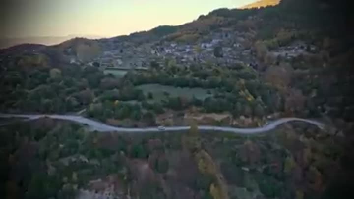 A winding mountain road leads to a remote town, signifying difficult access.