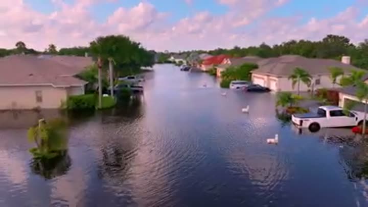Residential street submerged by floodwaters, showing the consequences of building in low-lying areas.