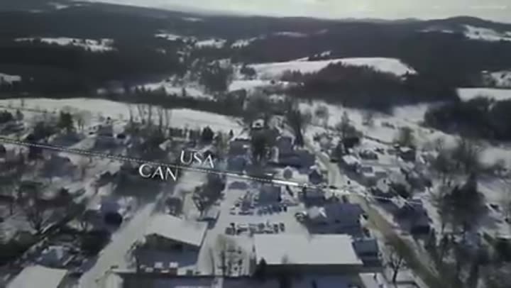 Aerial view of the snowy US-Canada border, illustrating geographical boundaries.