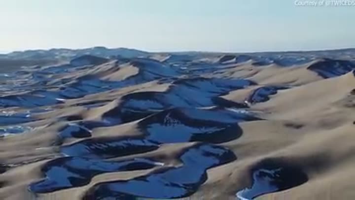 Unique snow-covered sand dunes create a striking and untamed winter landscape.